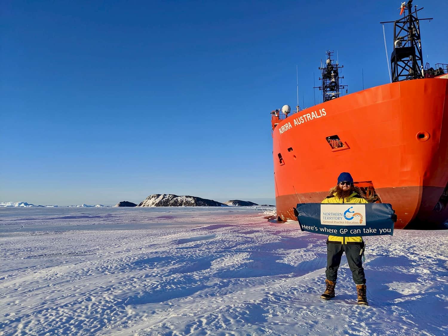 Dr Rhys Harding in Antarctica in front of Aurora Australis icebreaker ship